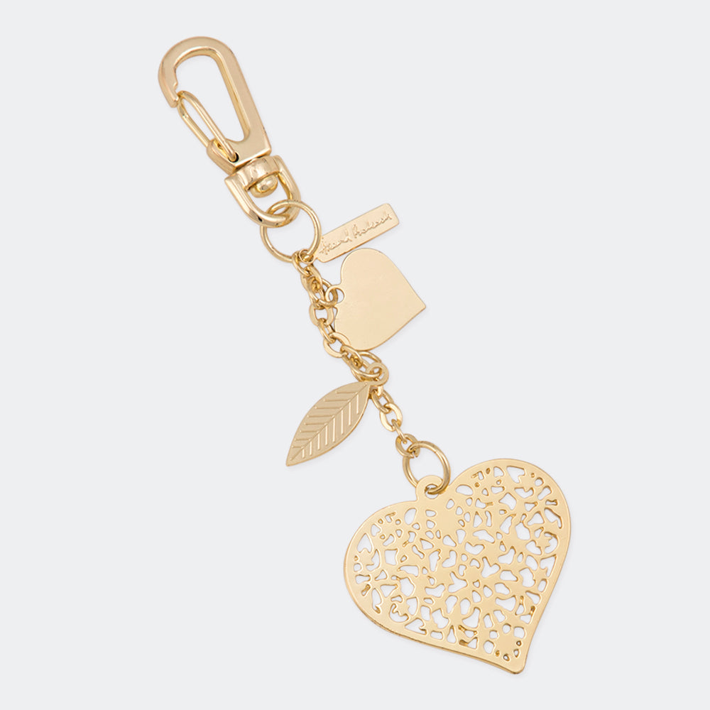 A gold-colored metal bag charm with a heart pattern, electroplated for a shiny finish, attached to a keychain ring. The charm is displayed on a dark background.