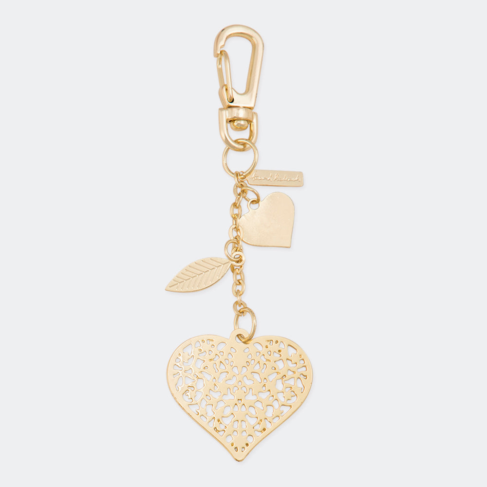 A gold-colored metal bag charm with a heart pattern, electroplated for a shiny finish, attached to a keychain ring. The charm is displayed on a dark background.
